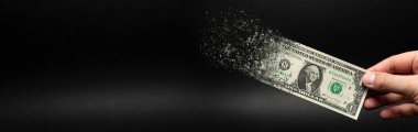 Enflasyon, dolar hiperenflasyonu. Siyah arka planlı pankart. Bir dolarlık banknot siyah arka plandaki bir adamın eline sıkılır. Satın alma gücü ve enflasyon kavramı.