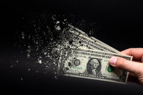 Enflasyon, dolar hiperenflasyonu ve siyah arka plan. Bir dolarlık banknot siyah arka plandaki bir adamın eline sıkılır. Satın alma gücü ve enflasyon kavramı.