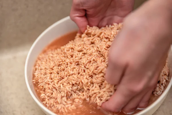 Cocinar el pilaf en un caldero, una receta para el pilaf real. Remoja el arroz en un recipiente con agua antes de cocinarlo. Devzira arroz para pilaf. Cocinar pilaf en casa — Foto de Stock