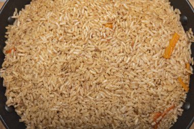 Pilaf pilavı yakın çekim. Doğu mutfağı konsepti. Dökme demir bir tavada eti olan Özbek pilavı. Üst manzara, kuzu, devzira pirinç.