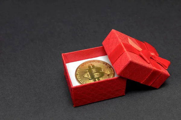 Regalo BTC. Bitcoin en una caja de regalo roja sobre un fondo negro. Tarjeta postal para imprimir, banner con lugar para texto. — Foto de Stock