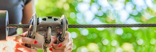 Équipement de sécurité dans le parc d'aventure forestier. L'utilisation d'équipements pour l'alpinisme : mousqueton, ceinture, corde. Bannière pour la publicité, le design ou l'en-tête de site Web — Photo