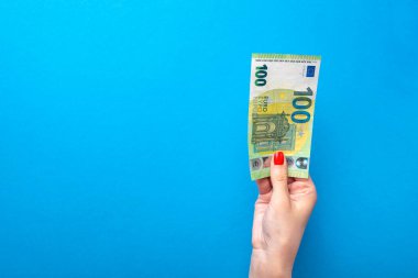 Elinde para, elinde banknot olan bir poster. Mavi arka planda 100 avroluk banknot var. Finansal temalar için mavi arkaplan