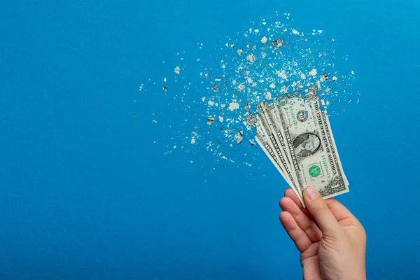 Inflatie, dollarinflatie. Banner met blauwe achtergrond. Een dollarbiljet wordt gespoten in de hand van een man op een blauwe achtergrond. Prijsstijgingconcept. — Stockfoto