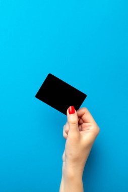 İndirim kartı elinde. Kara Cuma. Bir kadın mavi arka planda siyah indirim kartı tutuyor. Reklam ya da basım afişi. Metin için yer