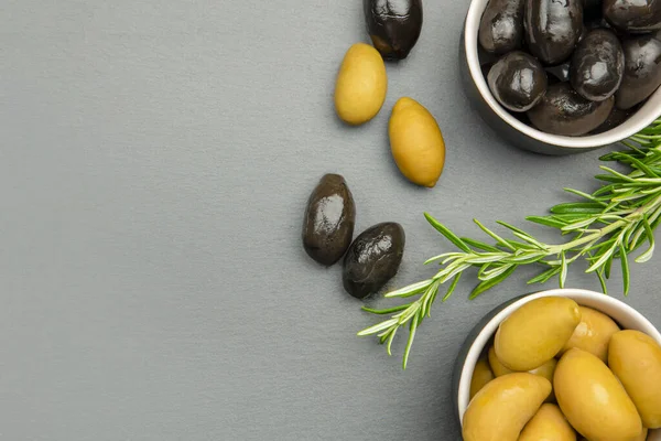 검은 올리브와 푸른 올리브가 있노라. 이탈리아의 올리브 열매를 맺는다. 유색 올리브와 로즈마리가 검은 돌 카운터 위에 놓여 있다. 원문을 위한 장소가 있는 광고용 요리용 기나 포스터 — 스톡 사진
