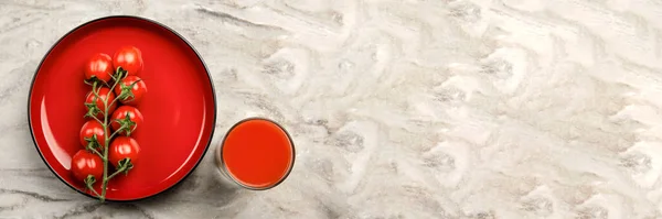 Un vaso de jugo de tomate y una rama de pancarta de tomates pequeños. Tomates cherry en un plato rojo sobre un fondo de mármol. Lugar para insertar texto o diseño —  Fotos de Stock