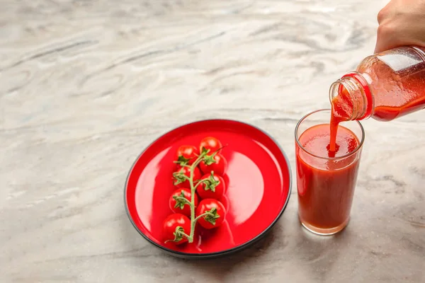 Vierta el jugo de tomate en un vaso. Mano vierte el jugo de tomate de la botella en vidrio, fondo de mesa de mármol. Espacio de copia de banner —  Fotos de Stock