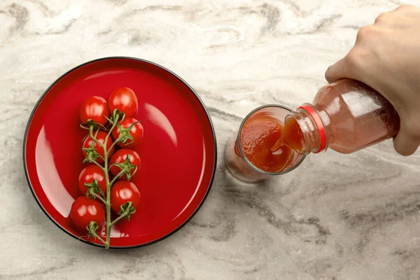 Tomatensaft in ein Glas gießen. Hand gießt Tomatensaft aus der Flasche in Glas, Marmor Tischplatte Hintergrund. Kopierraum für Banner — Stockfoto