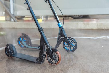 Yüksek basınçlı suyun altında kirli bir scooterı yıkamak. Mobiletin bakımını ve temizliğini