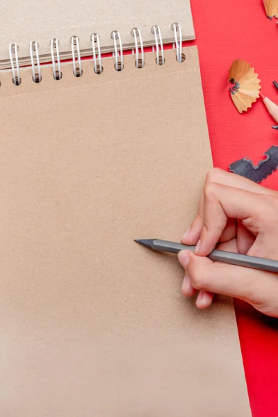 Barnet ritar med en penna i en anteckningsbok. Tomma blad för att infoga text eller bilder. Tillbaka till skolan. Begreppet början av läsåret. — Stockfoto