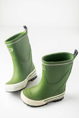 Beyaz arkaplanda izole edilmiş yeşil lastik çizmeler.