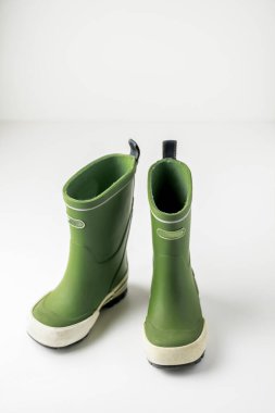 Beyaz arkaplanda izole edilmiş yeşil lastik çizmeler.