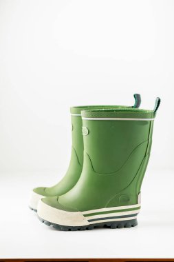 Beyaz arkaplanda izole edilmiş yeşil lastik çizmeler.