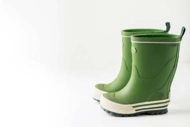 Beyaz arkaplanda izole edilmiş yeşil lastik çizmeler.