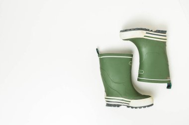 Beyaz arkaplanda izole edilmiş yeşil lastik çizmeler.