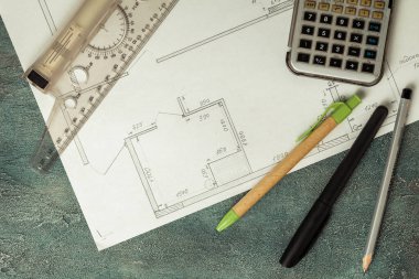 Yeni apartman planının taslağı. Hesap makinesi kalem ve kalem, gri renkli beton arka planda cetvel