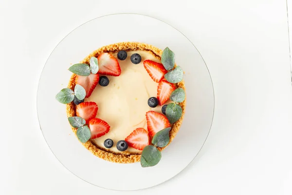 배경에는 딸기와 블루베리로 전통적 케이크가 오버헤드 — 스톡 사진