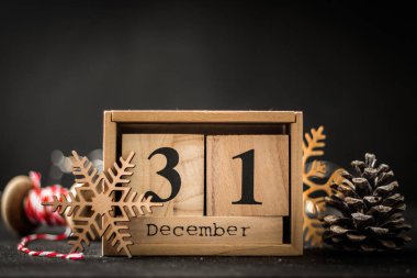 Siyah zemin üzerinde 31 Aralık tarihli tahta blok takviminin kapanışı. Yılbaşı ve Noel tatili