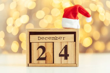 24 Aralık tarihli tahta takvim, yılbaşı ve yeni yıl arkaplanı bulanıklaştı. Güzel, sıcak ışık bokeh. Mutlu Noeller..