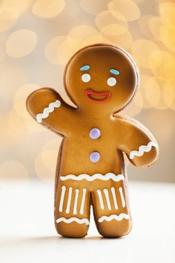 Bulanık Noel ışıkları arka planında zencefilli kurabiye. Sıcak bokeh ışıkları. Makro atış. Yılbaşı ve kış tatili geçmişi. Kış kahve zamanı.