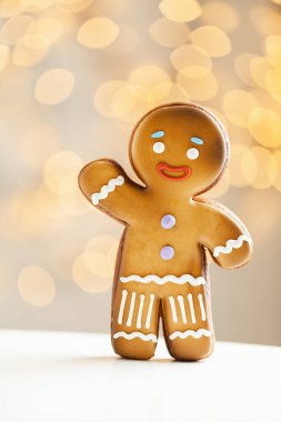 Bulanık Noel ışıkları arka planında zencefilli kurabiye. Sıcak bokeh ışıkları. Makro atış. Yılbaşı ve kış tatili geçmişi. Kış kahve zamanı.