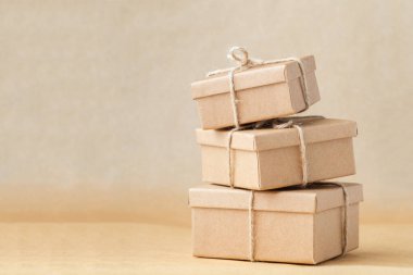 Kahverengi geri dönüşümlü arka planda halatla bağlanmış karton kutular. Teslimat için çevre dostu paketleme. Geri dönüştürülebilir materyaller