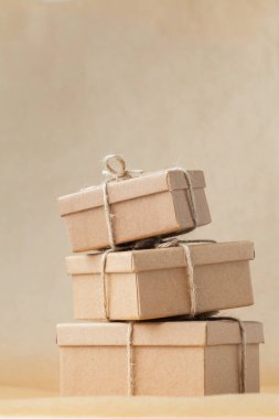 Kahverengi geri dönüşümlü arka planda halatla bağlanmış karton kutular. Teslimat için çevre dostu paketleme. Geri dönüştürülebilir materyaller