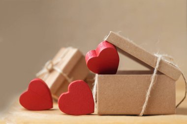 Sevgililer Günün kutlu olsun. Hediyenin ve hediyenin çevre dostu paketi. Karton kutu halatla bağlanmış, kahverengi geri dönüşümlü kağıtta kırmızı kalpler var. Aşk ifadesi