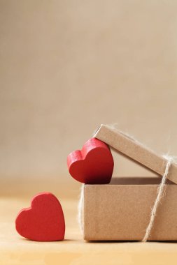 Sevgililer Günün kutlu olsun. Hediyenin ve hediyenin çevre dostu paketi. Karton kutu halatla bağlanmış, kahverengi geri dönüşümlü kağıtta kırmızı kalpler var. Aşk ifadesi