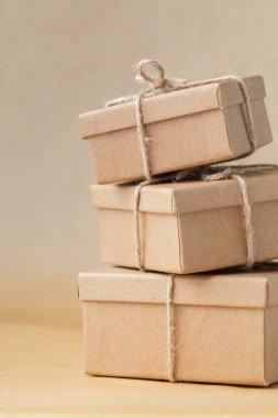 Kahverengi geri dönüşümlü arka planda halatla bağlanmış karton kutular. Teslimat için çevre dostu paketleme. Geri dönüştürülebilir materyaller
