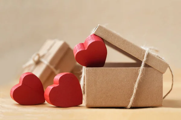 ハッピーバレンタインデー 贈り物とプレゼントの環境に優しい包装 段ボール箱は 茶色の再生紙の背景に赤い心を持つロープで結ばれています 愛の表現 — ストック写真