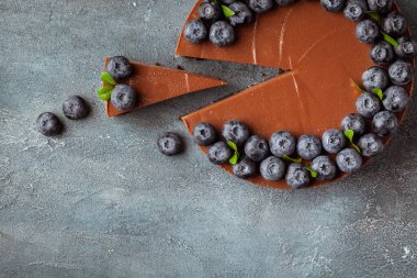 Klasik beton arka planda taze yaban mersinli çikolatalı cheesecake. Düz yatıyordu