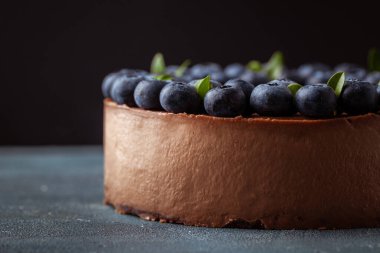 Klasik beton arka planda taze yaban mersinli çikolatalı cheesecake..