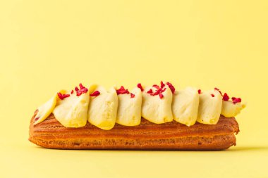 Tereyağı kremalı ve orijinal dekorasyonlu taze ekler. Sarı arka planda Fransız pastası. Makro çekim