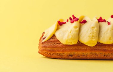 Tereyağı kremalı ve orijinal dekorasyonlu taze ekler. Sarı arka planda Fransız pastası. Makro çekim