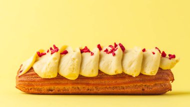 Tereyağı kremalı ve orijinal dekorasyonlu taze ekler. Sarı arka planda Fransız pastası. Makro çekim