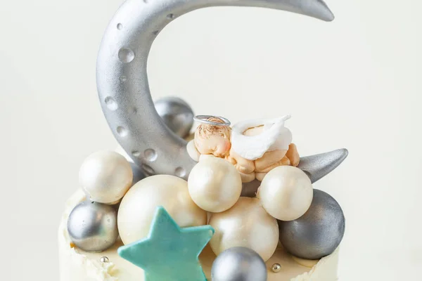赤ん坊の天使が寝ているケーキを洗礼する 銀の月とチョコレートの装飾で作られた球と新生児のお祝いのためのパンケーキ — ストック写真