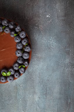 Klasik beton arka planda taze yaban mersinli çikolatalı cheesecake. Düz yatıyordu