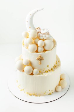 Çikolata beyaz toplar ve altın serpiştirilmiş beyaz vaftizli ranza pastası. Küçük bebek melek üstte uyuyor. Bebek doğumu kutlaması.