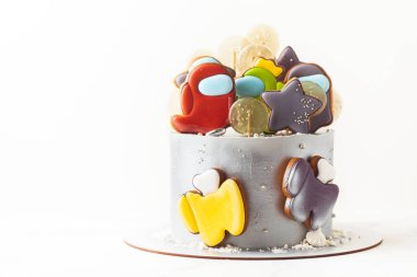 KYIV, UKRAINE - 26 Haziran: Online bilgisayar oyunu karakterleri şeklinde zencefilli kurabiyelerle süslenmiş doğum günü pastası. Aramızda kalsın. Beyaz arkaplanda temalı pasta