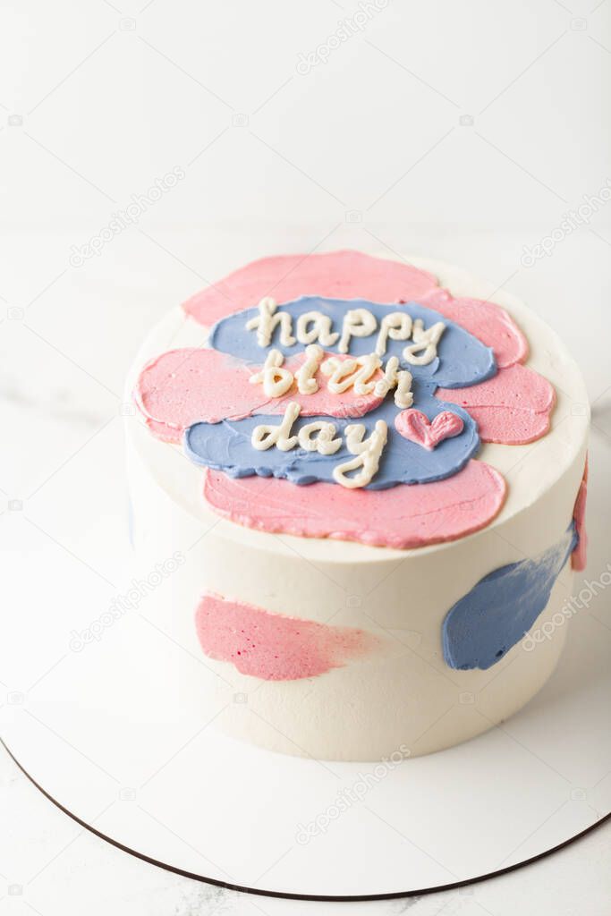 White cake with cream cheese frosting and Happy birthday text on the top.