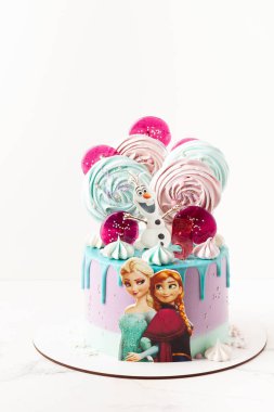 Kyiv, Ukrayna - 03 Mart 2021: Disney karakteri Elsa ve kız kardeşi Anna ve arkadaşı Olaf Kardan Adam kurabiyeleri doğum günü pastasının üstünde. Donmuş çizgi film karakterleri. Beyaz arkaplan