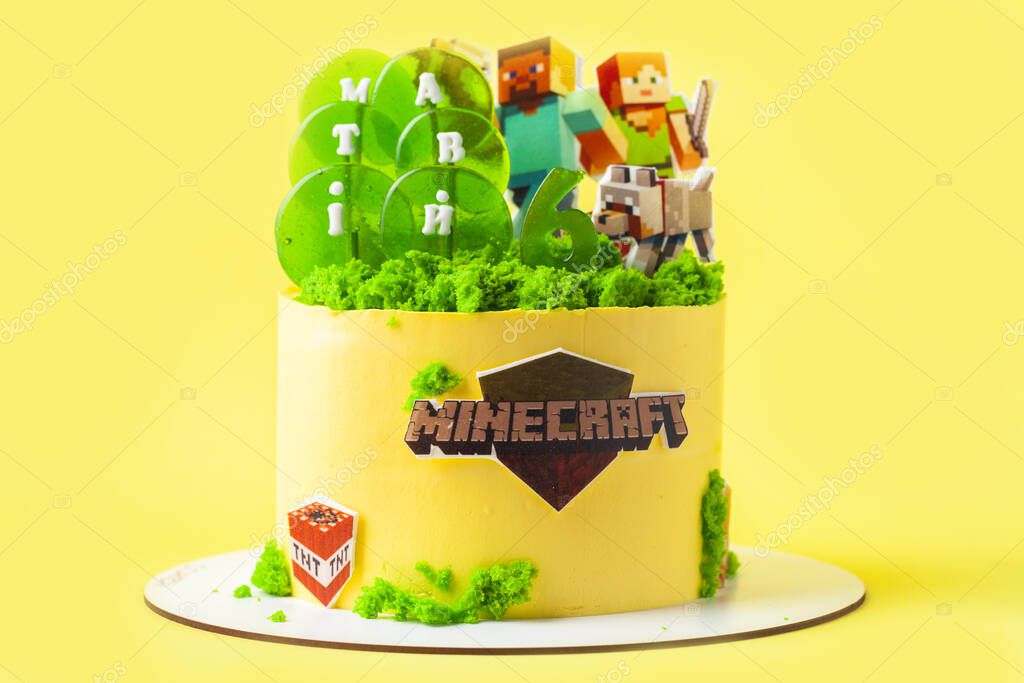 Kyiv, Ukraine - May 24, 2021: Birthday cake for a fan of Minecraft game on yellow background. Cake for a gameboy decorated with edible green grass