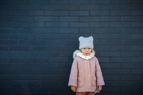 Nieśmiały Cute Little Girl Stoi Ciemnej Ścianie Cegły — Zdjęcie stockowe