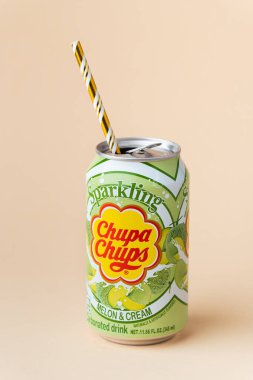 Kyiv, Ukrayna - 24 Mayıs 2025: Chupa Chups alkolsüz köpüksüz kavun aromalı meşrubat bej arka planda bir teneke kutuda. Tropik yaz ferahlatıcı içecek konsepti