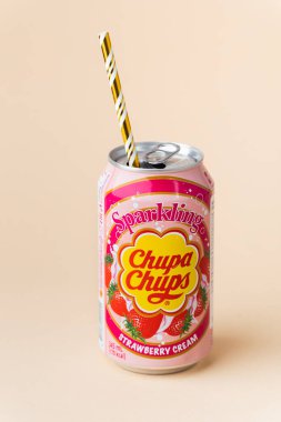 Kyiv, Ukrayna - 24 Mayıs 2025: Chupa Chups alkolsüz köpüklü çilek aromalı meşrubat bej arka planda bir teneke kutuda. Tropik yaz ferahlatıcı içecek konsepti