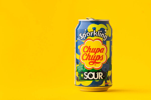 Киев, Украина - 19 июля 2025 года: безалкогольный игристый голубичный безалкогольный напиток Chupa Chups со вкусом черники в жестяной банке на желтом фоне. Тропическая концепция летнего освежающего напитка
