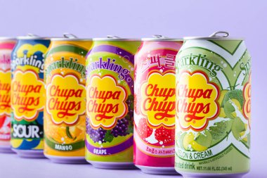 Kyiv, Ukrayna - 19 Temmuz 2025: Sarı arka plandaki teneke kutuda alkolsüz, farklı aromalı, köpüklü bir içecek seti. Tropik yaz ferahlatıcı içecek konsepti