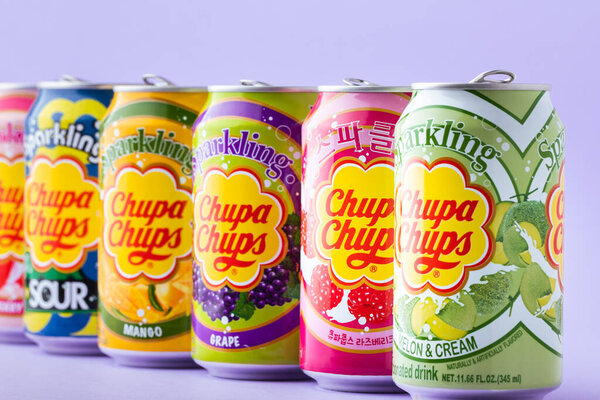 Киев, Украина - 19 июля 2025 года: Комплект Chupa Chups безалкогольный игристый с разным вкусом безалкогольный напиток в жестяных банках на желтом фоне. Тропическая концепция летнего освежающего напитка